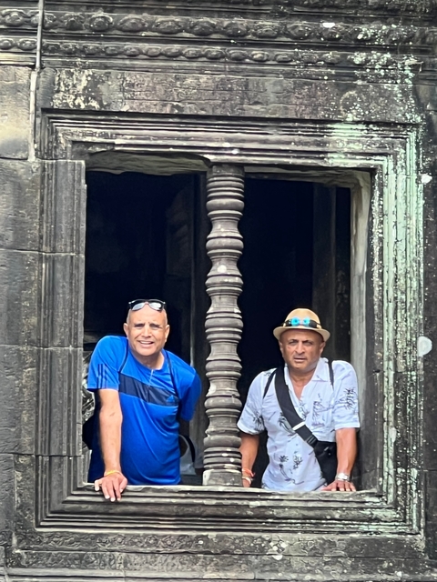 Two men posing in an ancient building.