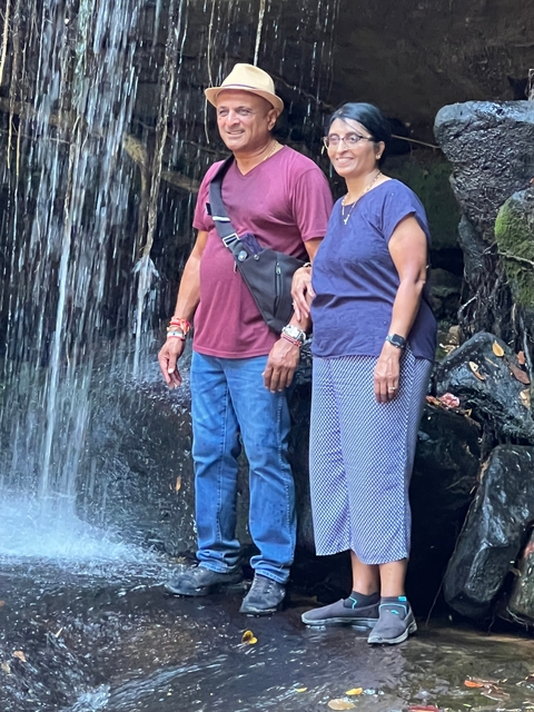 Couple standing in front of a waterfall.