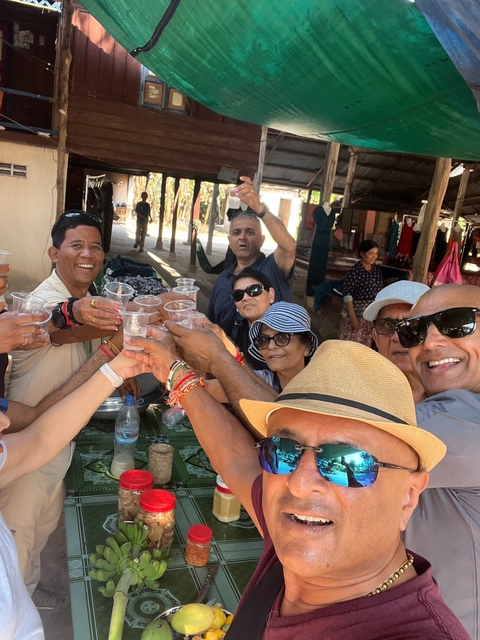 Group of people raising cups for a toast in an outdoor setting.