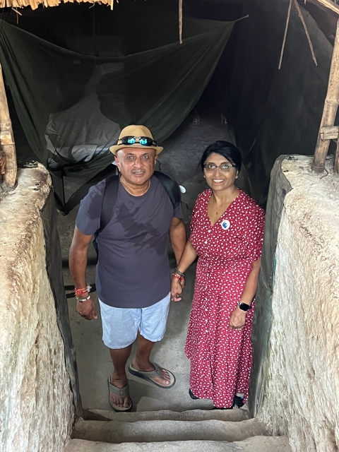 Couple holding hands standing in a cave.