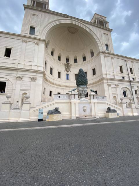 Exterior view of a white building with steps and sculptures.