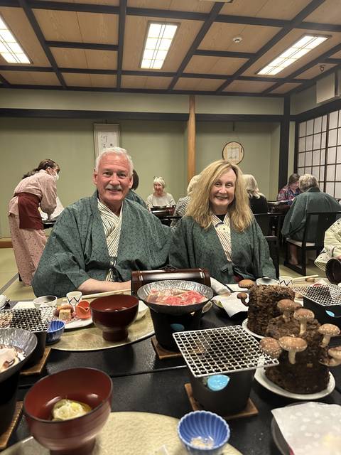 Couple in traditional Japanese attire enjoying a meal indoors.