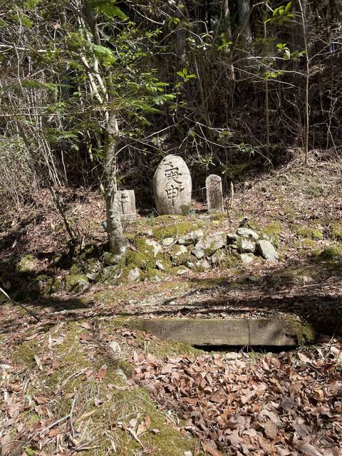 Stone tablet with Japanese characters surrounded by greenery.
