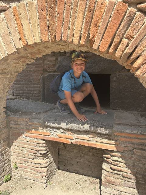Child posing playfully in a historic stone ruin.
