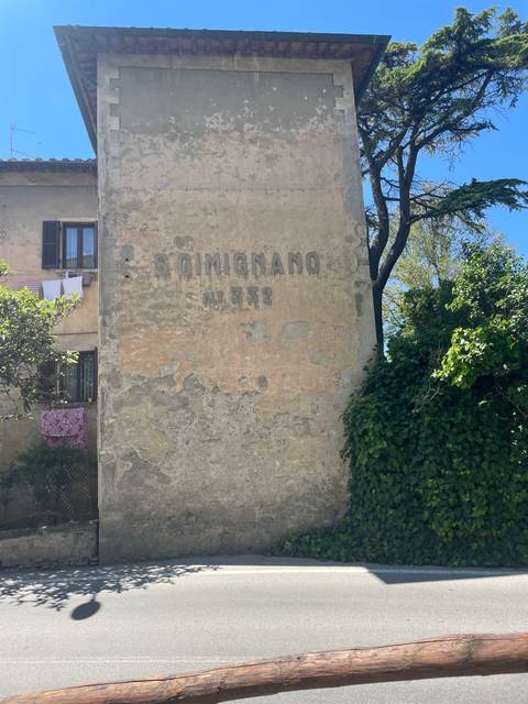 Old structure with a faded inscription 'S. GIMIGNANO'.