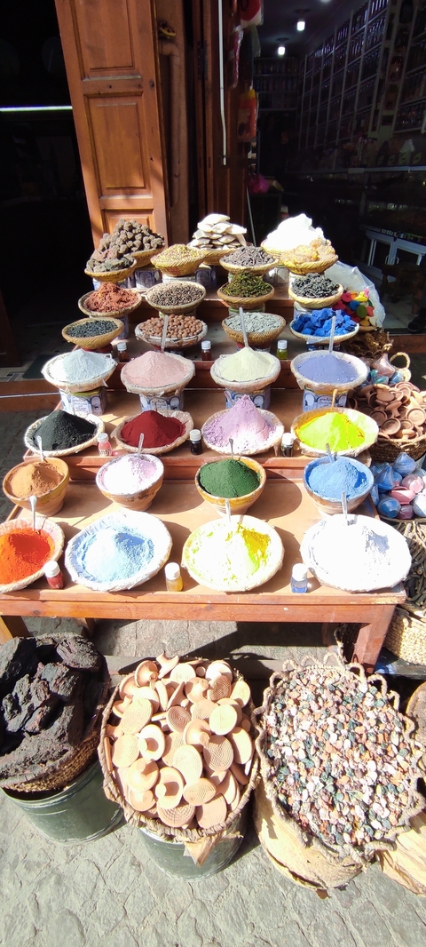Colorful spices displayed in baskets at a market.