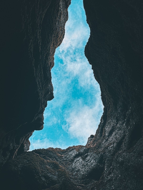 View of the sky through a rocky opening.
