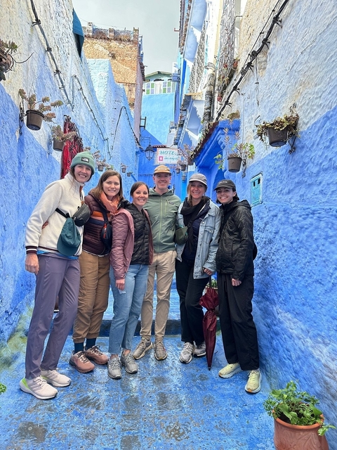 Group of people visiting blue-painted street.