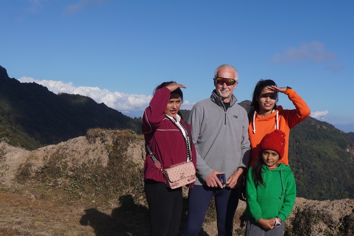 Group of people posing with scenic mountainous background
