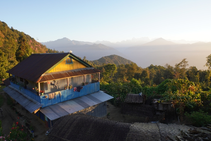 House on a hillside with mountains in the distance