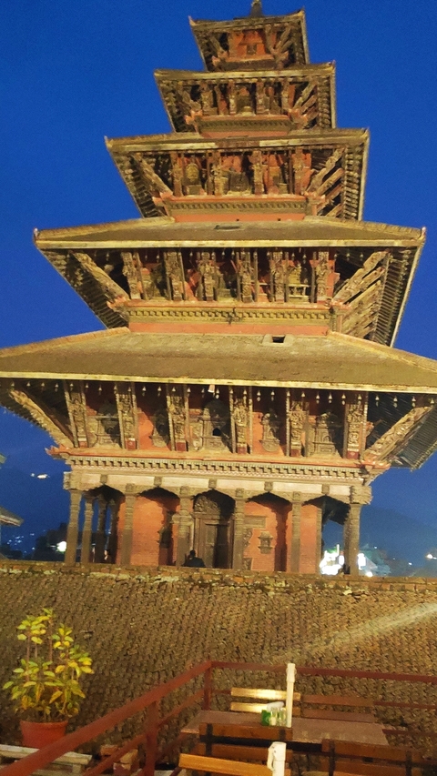 Traditional temple with intricate carvings illuminated at night.