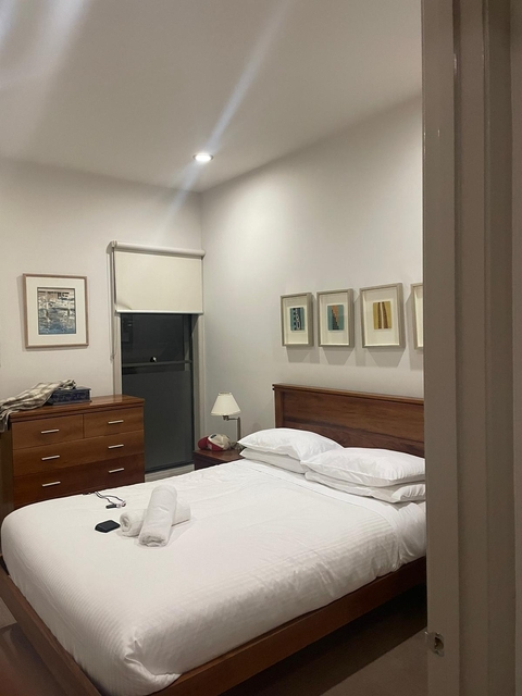 Interior of a simple bedroom with artwork on the wall.