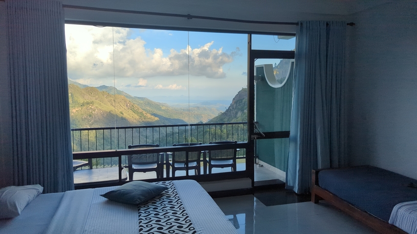 View from a window showing a mountainous landscape.