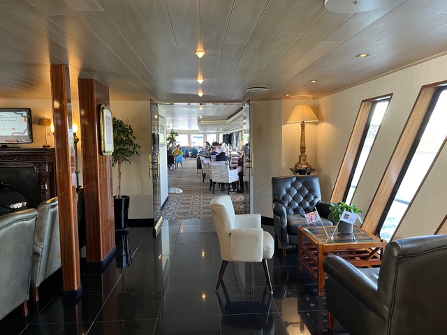 Interior view of a ship's lounge with seating.