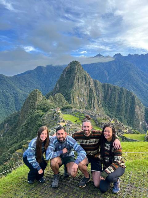 Group of people smiling with Machu Picchu in the background.