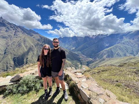 Couple overlooking a scenic valley with dramatic mountains.