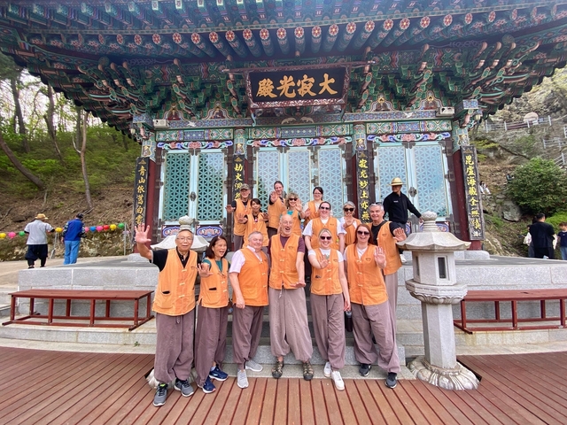 Tour group posing in front of a colorful traditional building.