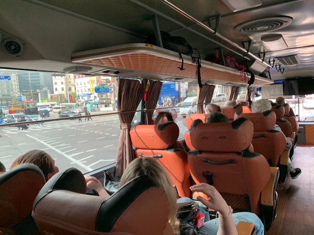 Interior of a coach bus with passengers looking out the window.