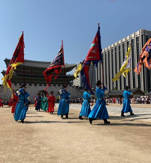 Traditional ceremony with procession of people in colorful attire.