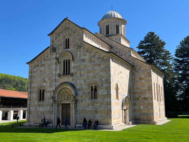 Large stone church with many visitors.