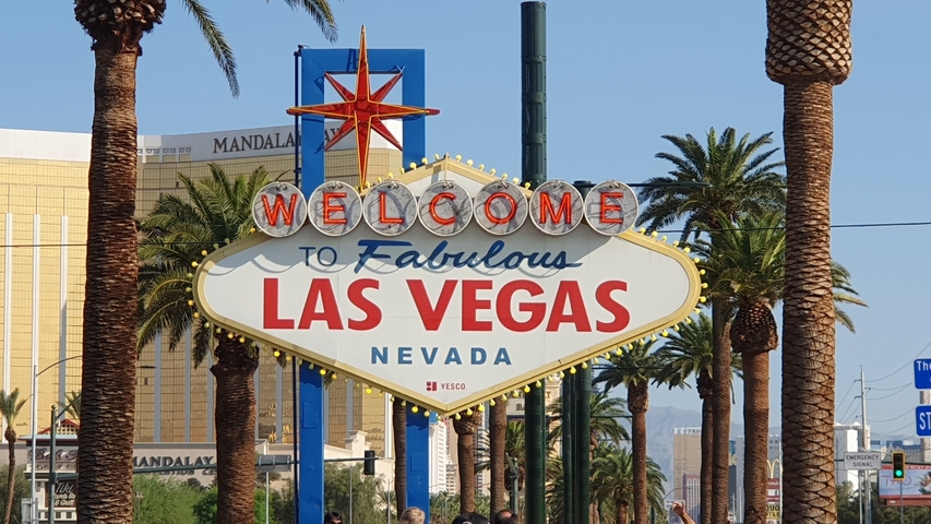 Welcome to fabulous Las Vegas sign with palm trees around.