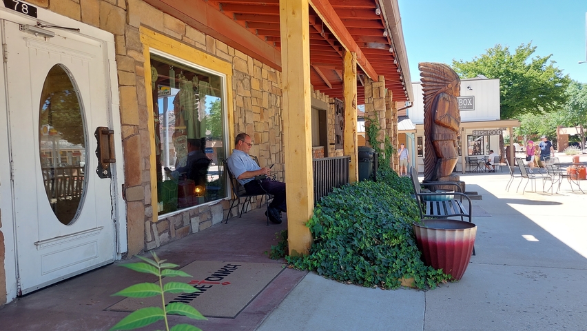 Street view with a man sitting outside a building.