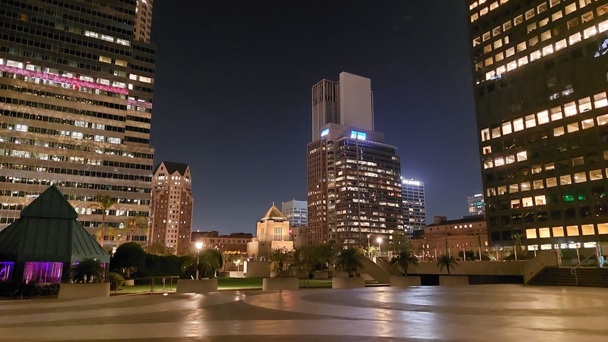 Night view of a city with modern buildings lit up.