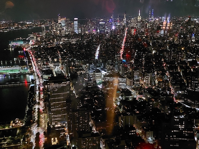 Night aerial view of New York City with bright lights.