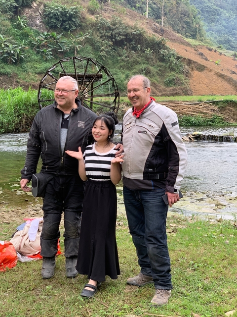 A group photo with a local by a stream.