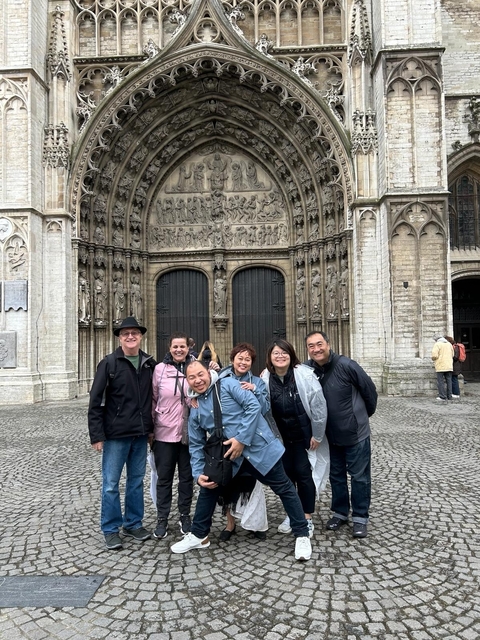 Group of people posing in front of a historic cathedral.