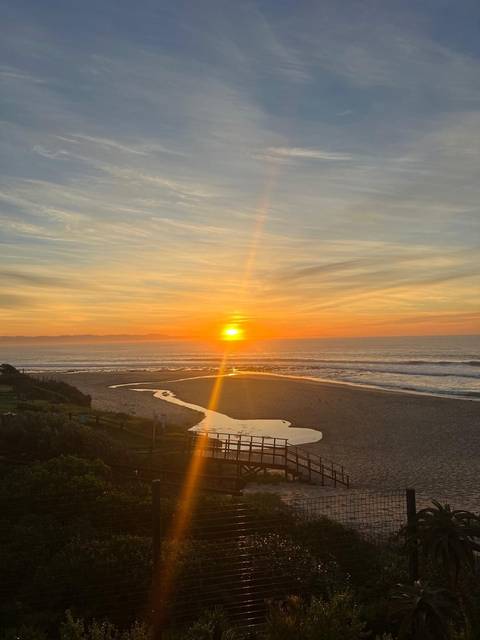 Breathtaking sunset view over a beach with a river flowing in.