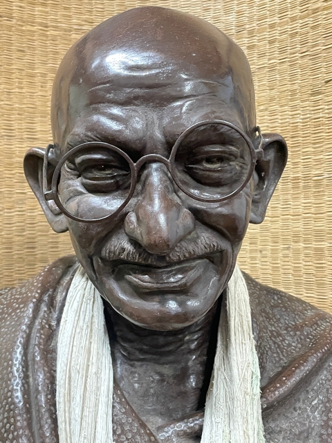 A close-up of a sculpture of a historical figure wearing glasses.