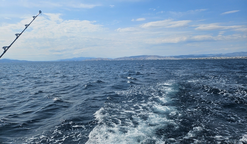 A view of the ocean with a boat's wake in the foreground.
