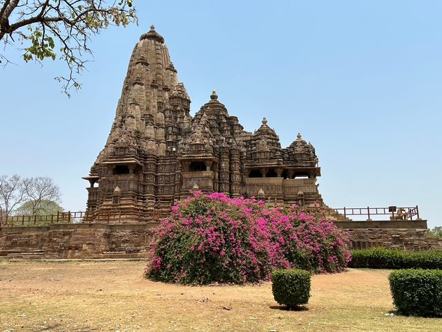 Ancient temple with intricate carvings and vibrant flowers.