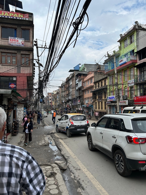 Busy street scene with cars and pedestrians in an urban area.