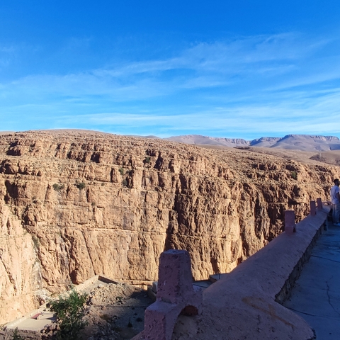 Wide view of a rocky desert landscape with a clear sky.