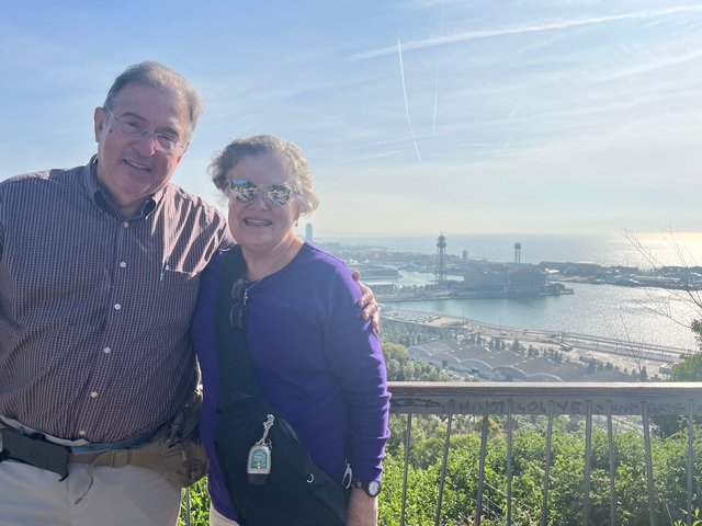 Elderly couple with harbor and city view.