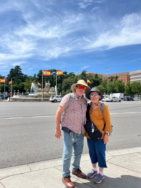 Couple posing with Spanish flags in the background.