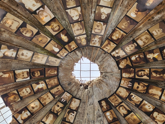 Circular ceiling with photographs and a central window.