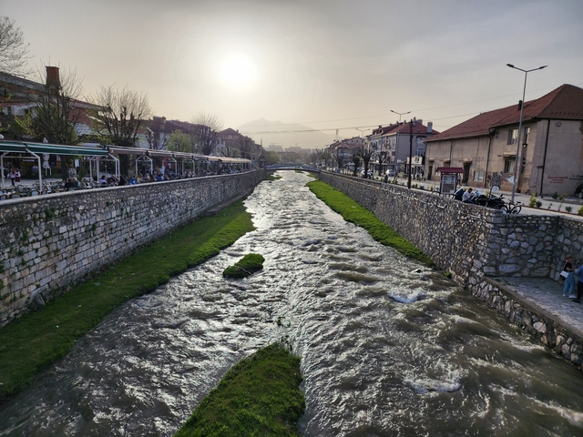 Stone canal with flowing river in a city.