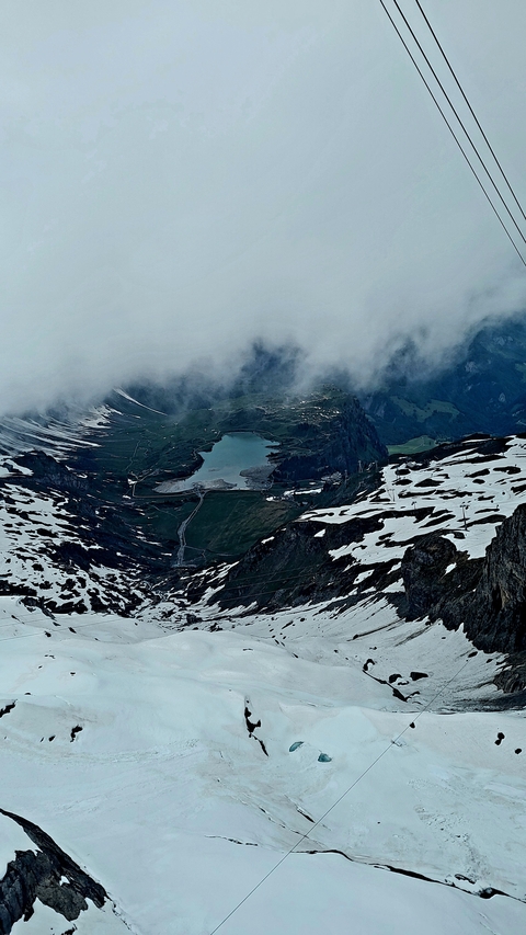 High mountain vista with snow and a lake below.