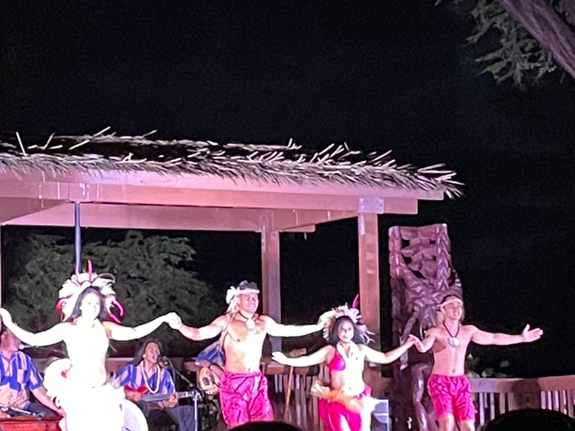 Nighttime hula performance on stage.