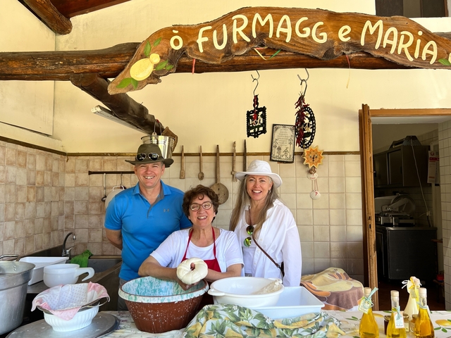 Three people posing in a kitchen, smiling.
