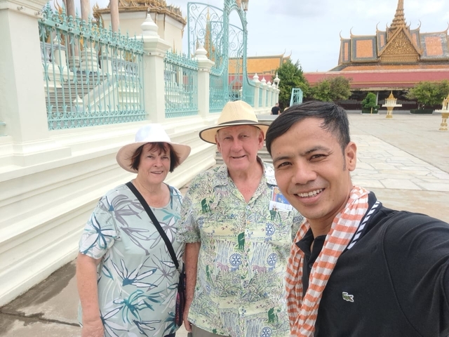 Three people posing for a selfie in front of a traditional building.