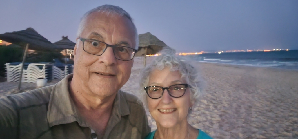Couple taking a selfie on a beach at sunset.
