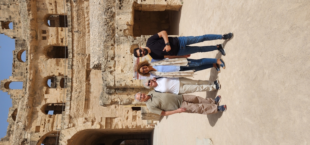 Group of people posing in front of ancient ruins.