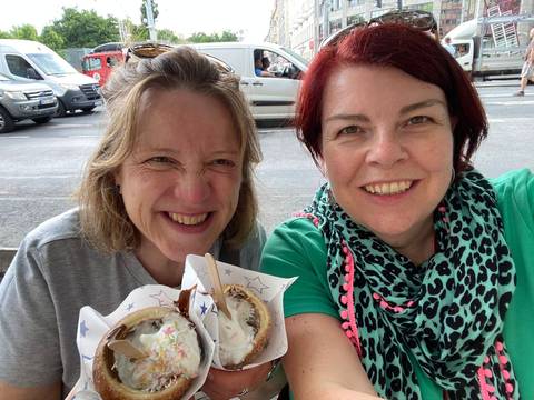 Two women smiling with desserts.