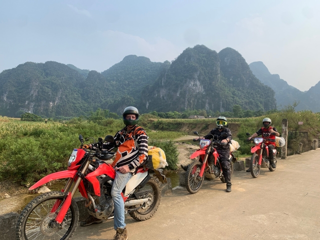 Motorcyclists on a scenic road with rocky hills.