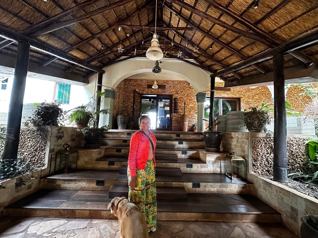 Person standing in front of a rustic lodge entrance.