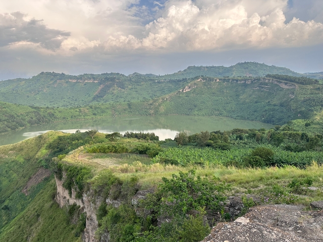 Scenic view of a crater lake surrounded by lush hills.